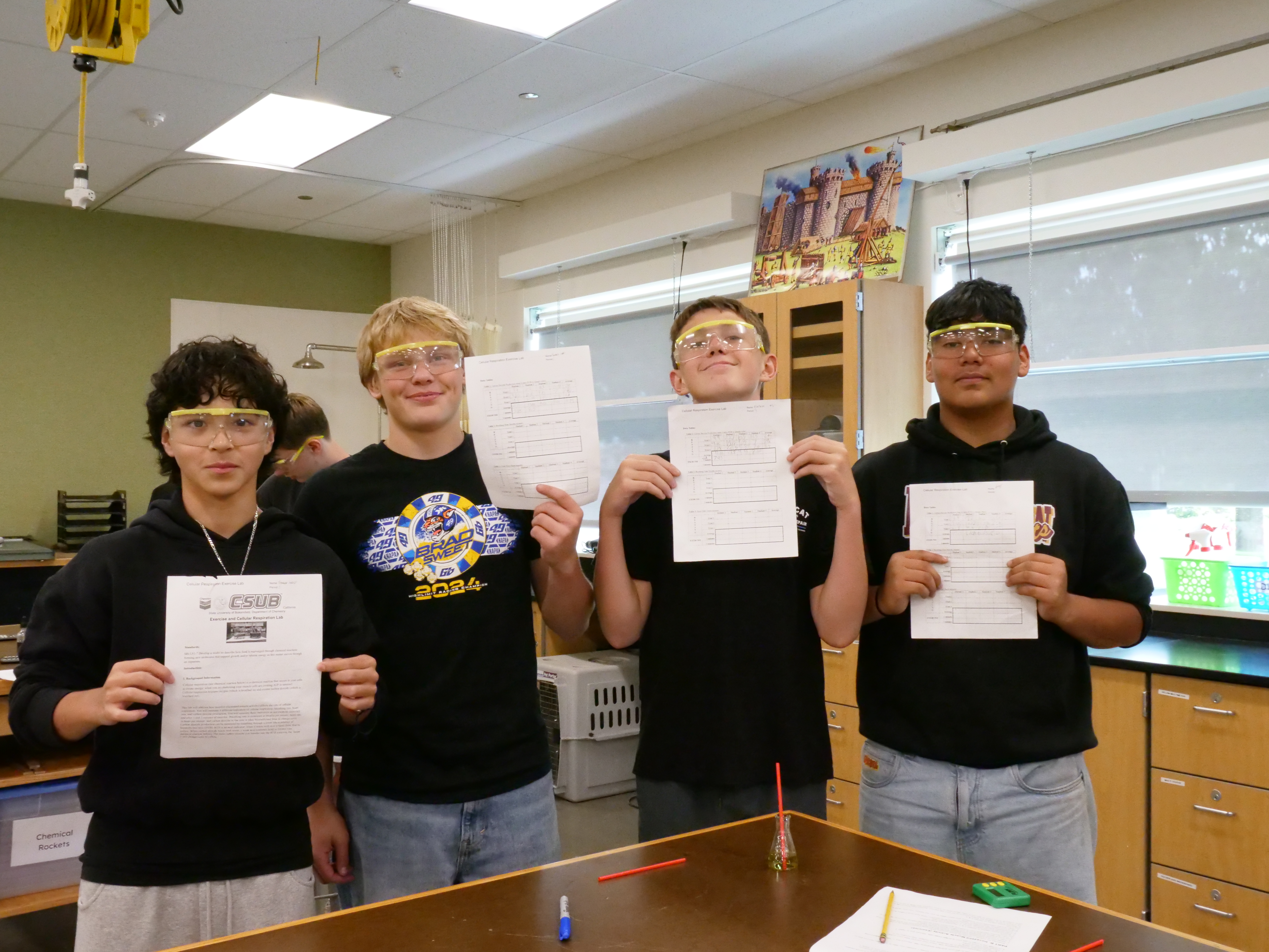 High school students holding up thier work in science