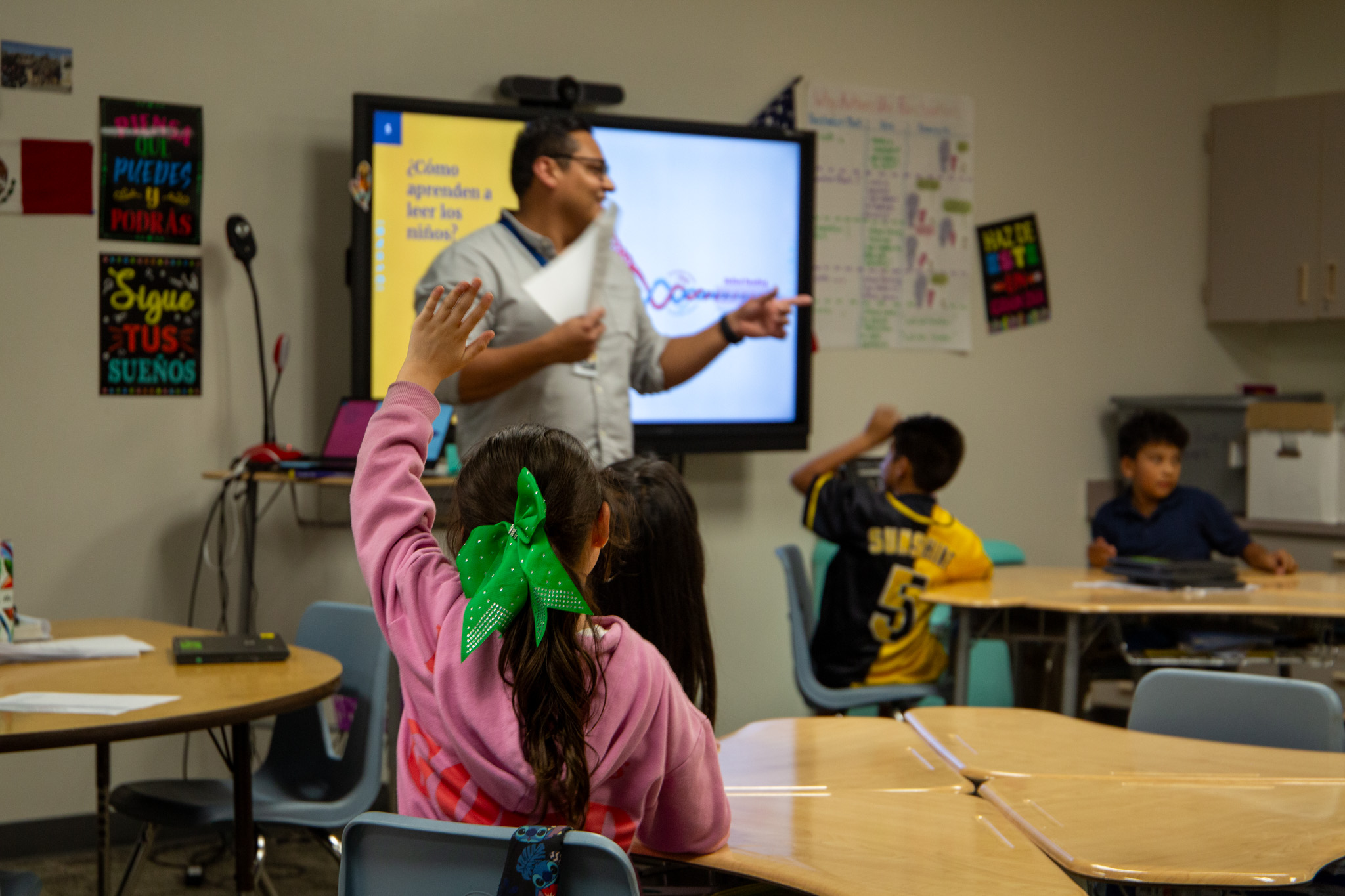 A student raises her hand in Mr. Gomez's class.