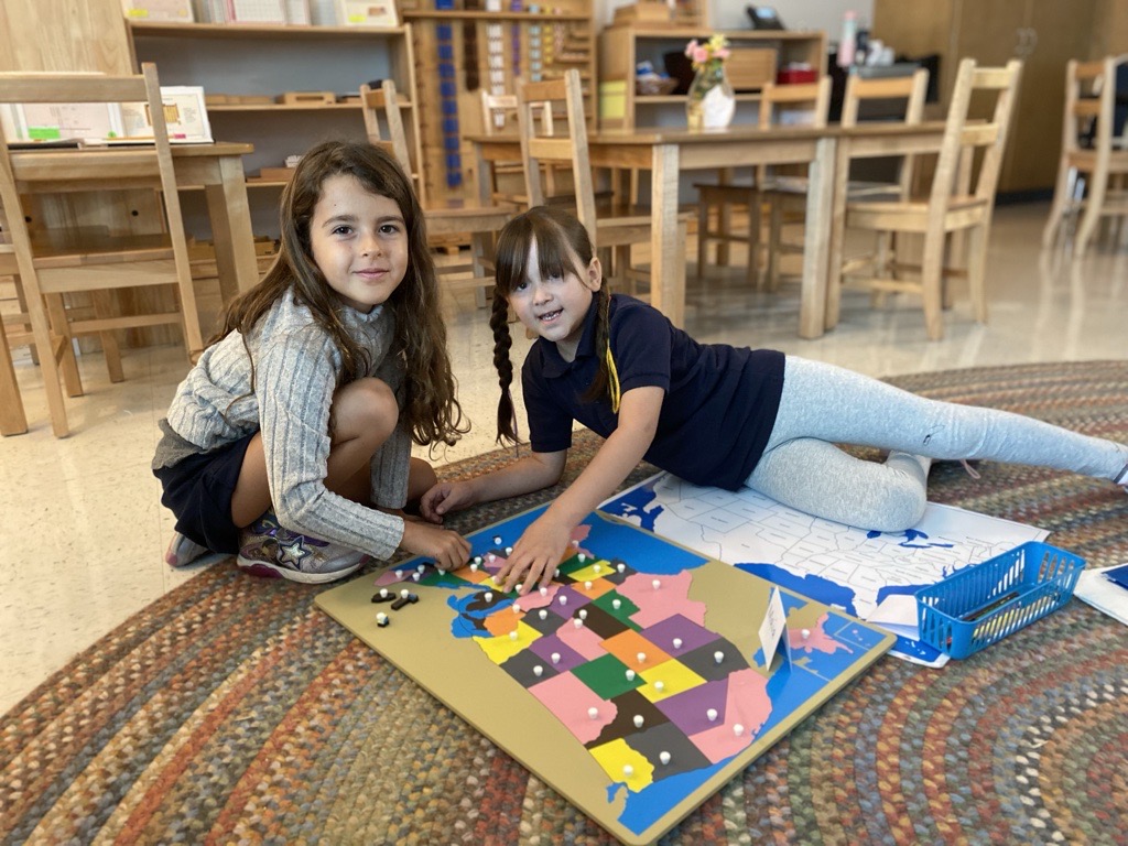 Two girls working on a puzzle map