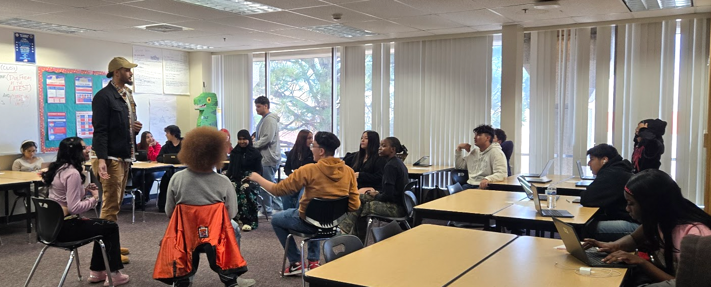 students sitting at desks watching their teacher