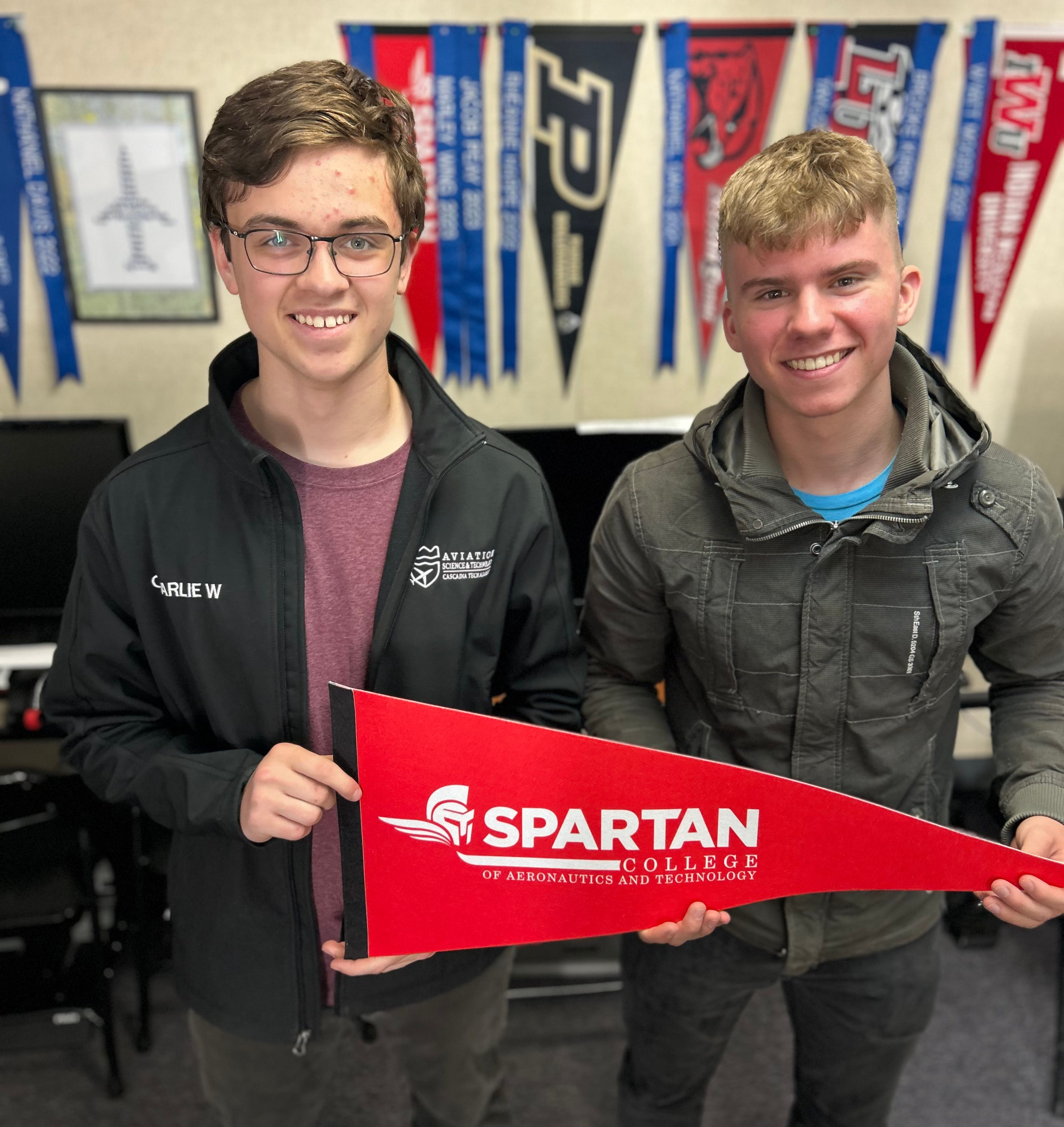 High school ROTC cadets hold a banner for Spartan College of Aeronautics
