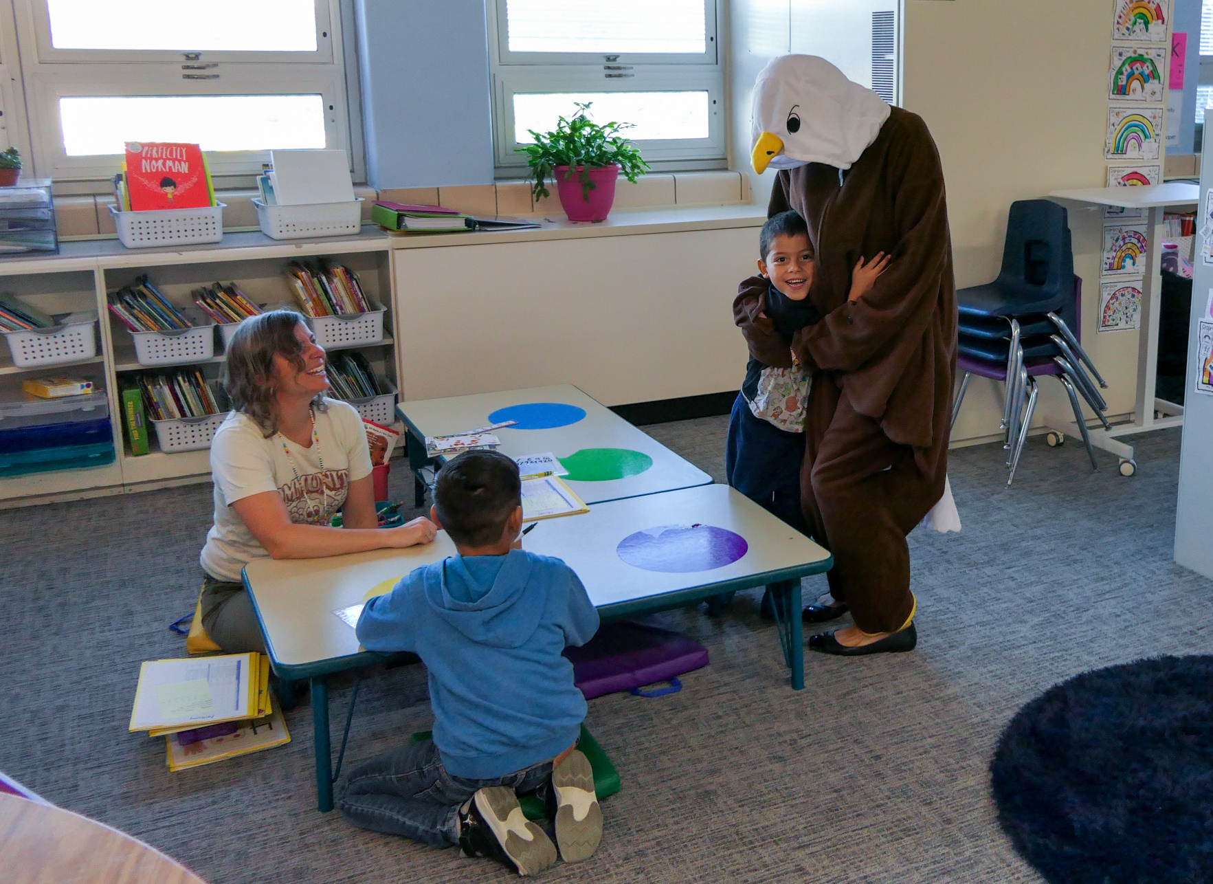 A student hugs Ellie the Eagle. Ellie was visiting classrooms to celebrate students with strong attendance. 