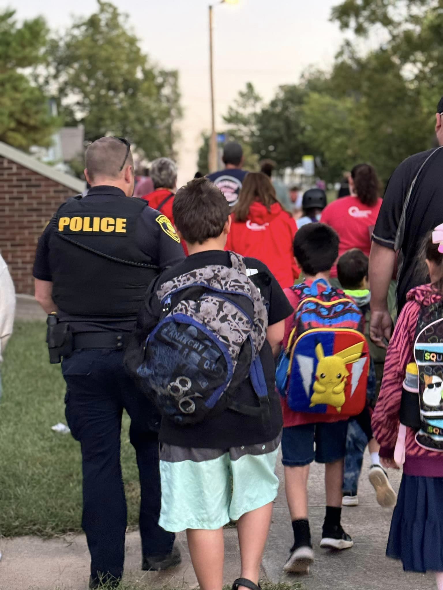 Students walking down street with officer