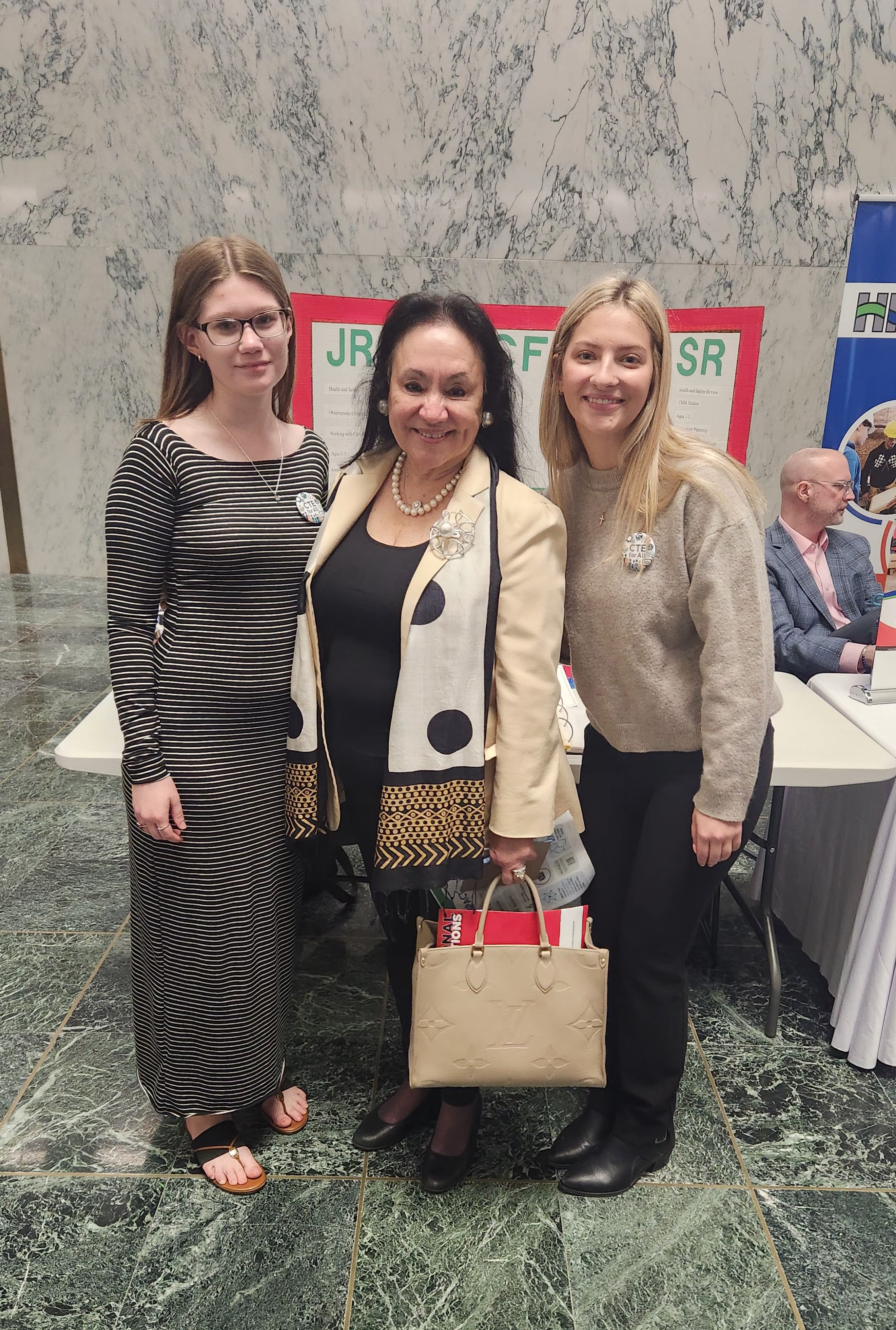 Two students and education commissioner posing