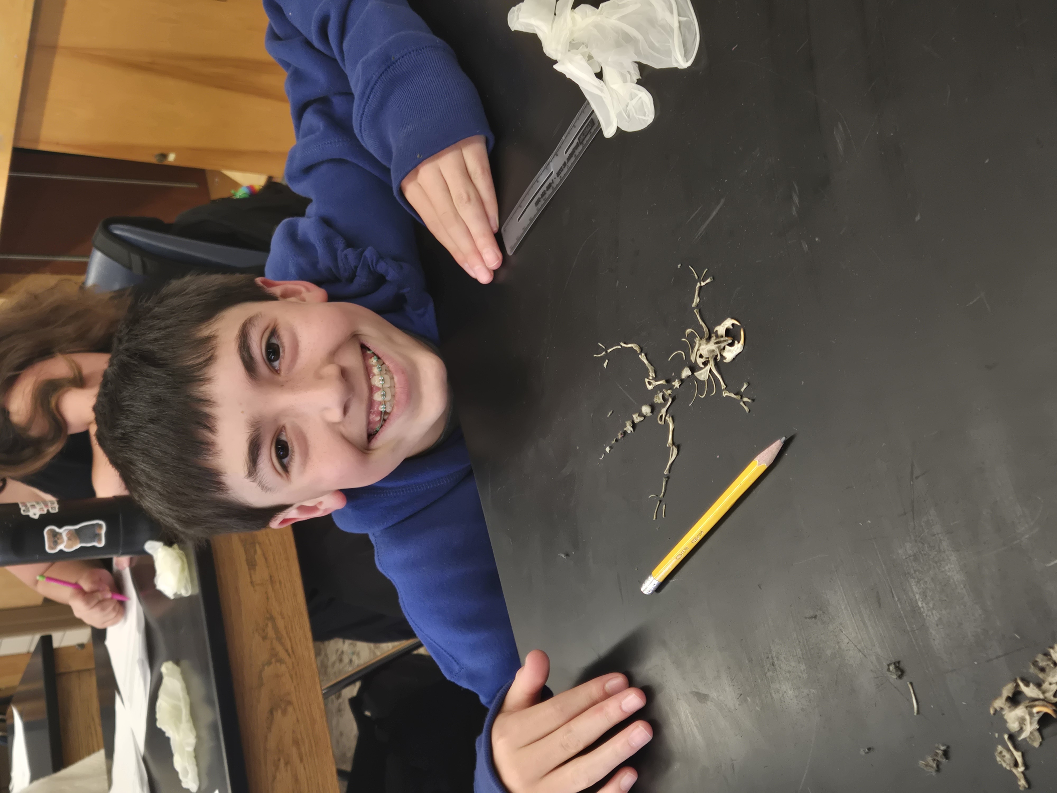 Luca Raizman poses next to their reconstructed rodent skeleton