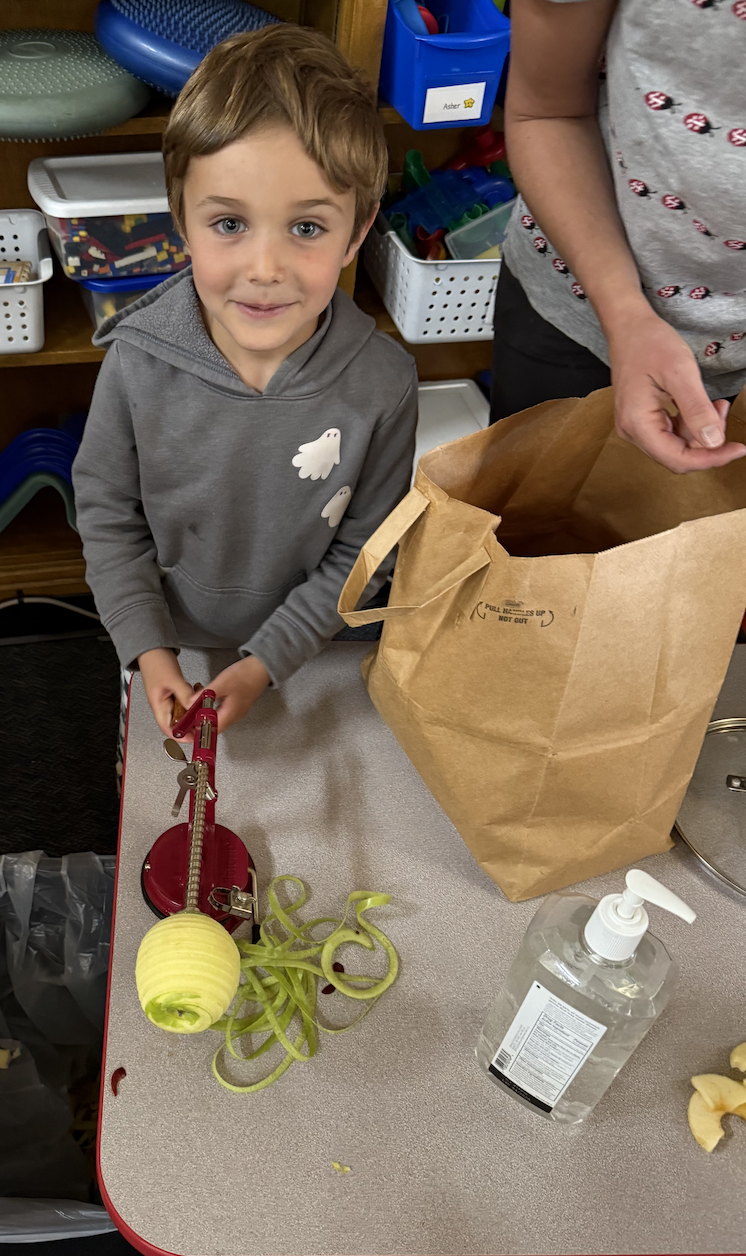 Kinder student peeling apple
